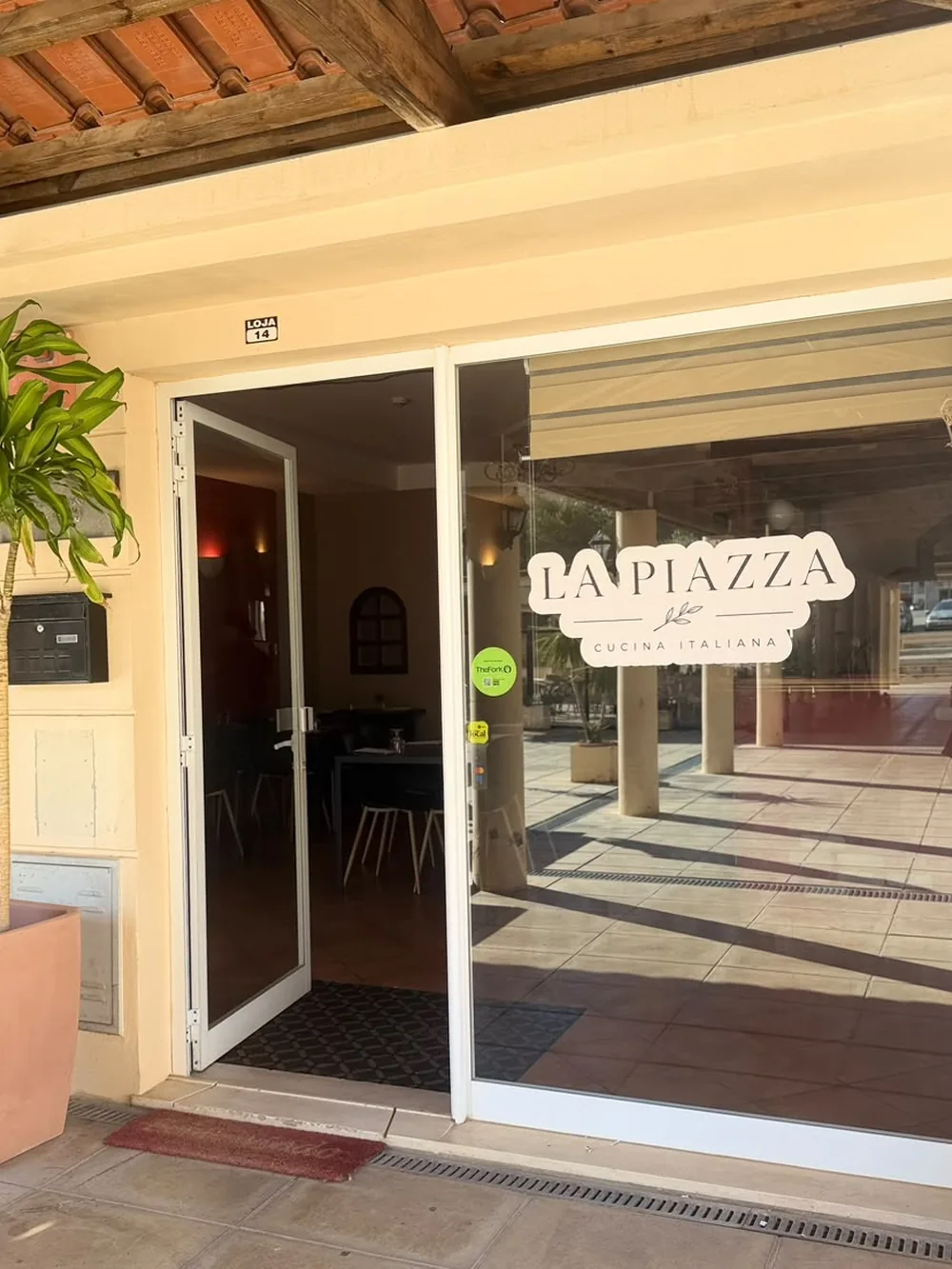Entrada da La Piazza, com o letreiro no vidro