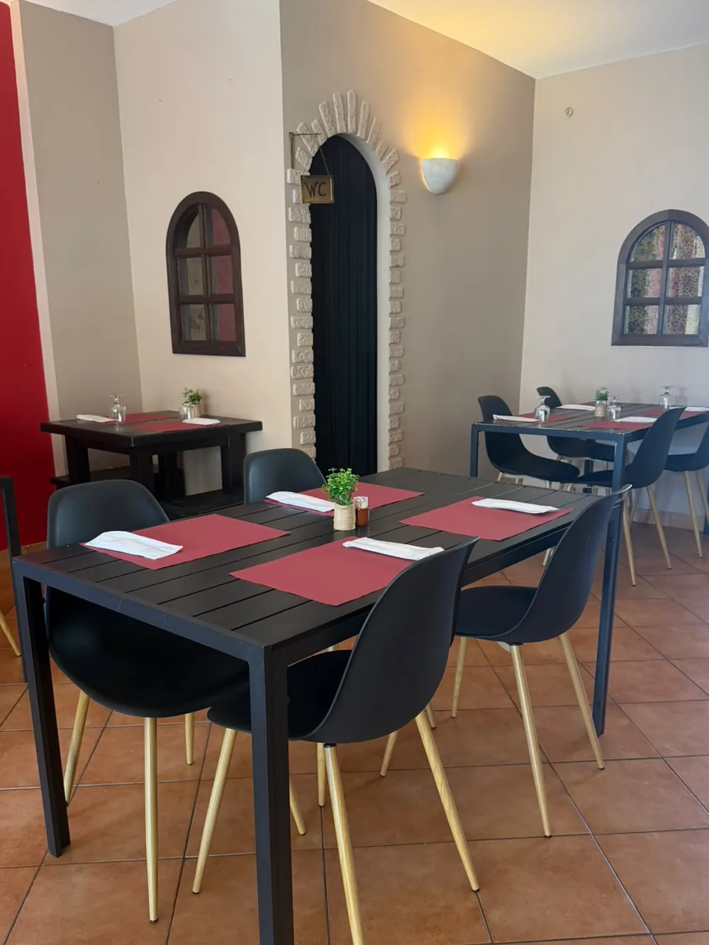 Sala da La Piazza, com mesas postas e individuais vermelhos